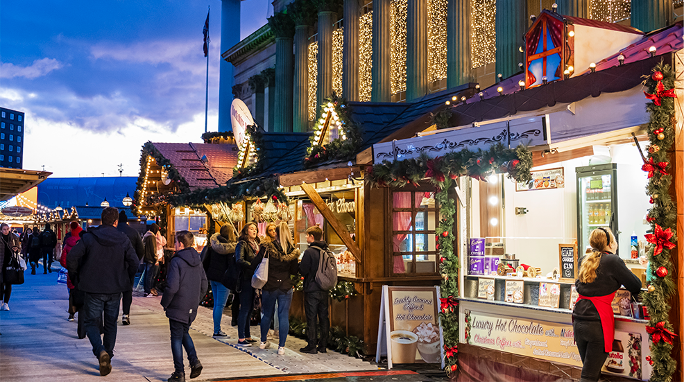 People at the Christmas Market set up in front of the Saint George's Hall, the multifunctional Neoclassical style building located in the Liverpool city centre.